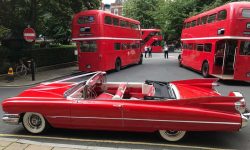 1959 Cadillac convertible in Festival Red (with Routemaster buses)